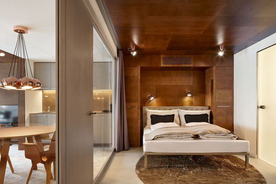 Hotelzimmer Ema House mit Holzverkleidung und Glaswand zum Wohnbereich