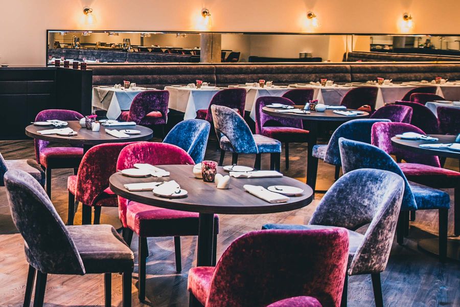 Restaurant-Einrichtung im Hotel mit pinken und blauen Stühlen