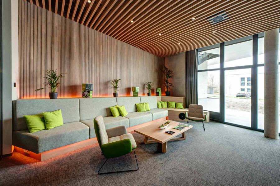 Minimalistische Experience Lounge mit raumhohen Fenstern und Holzlamellen