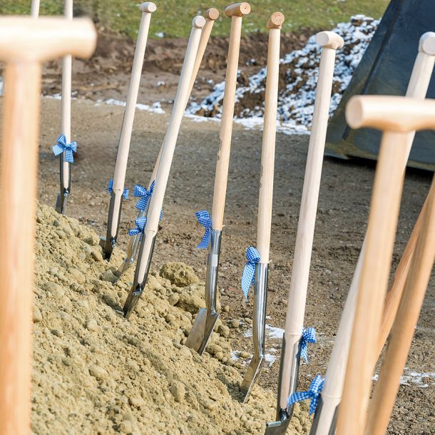 Spatenstich auf dem Firmengelände in Peterskirchen Dietersburg mit Schaufel und Schleife als symbolischer Baustart im Rottal-Inn