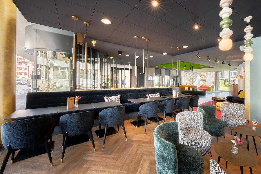 Lounge mit Sesseln Tischen und Barbereich in offener Verbindung mit Restaurantzone