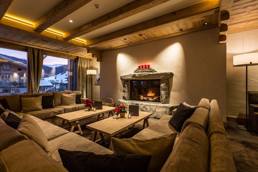 Hotellounge mit offenem Kamin, gem&uuml;tliche Sofas und warmen Lichkonzept