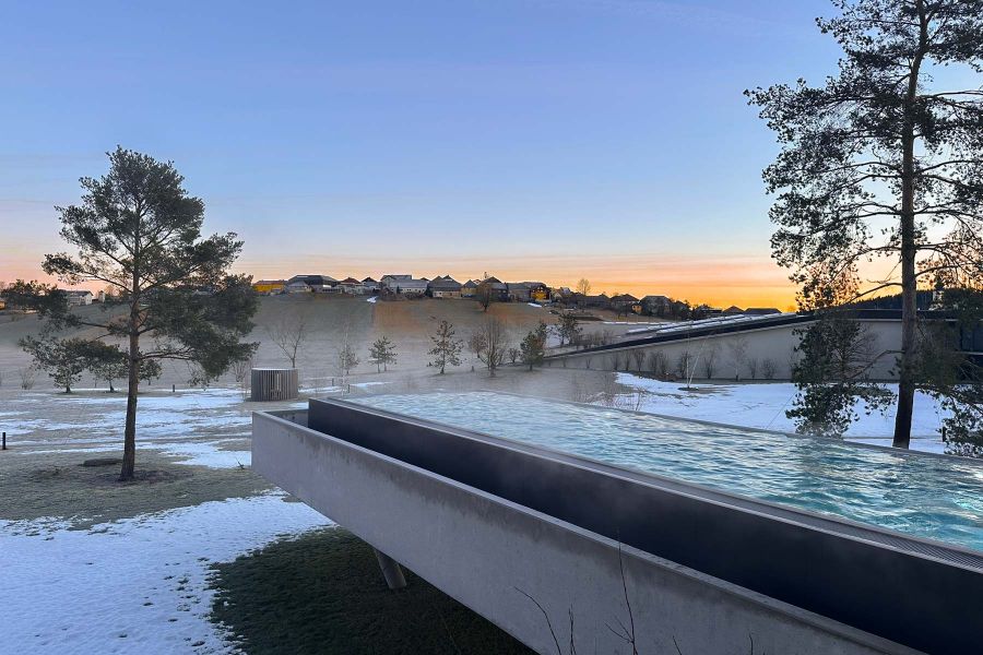 Infinity Pool mit Sichtbeton im Loxone Campus Kollerschlag bei Sonnenuntergang