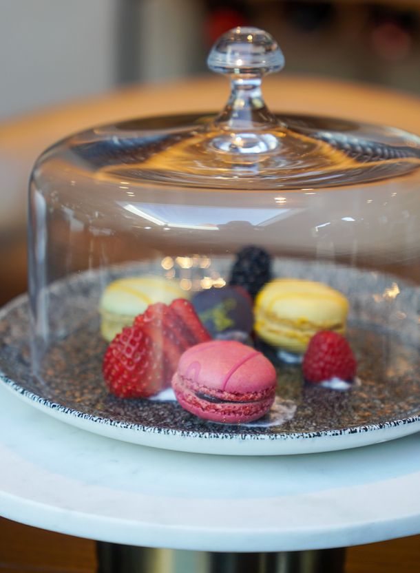 Nachspeise im Hotelrestaurant mit Macaron auf Keramikplatte ergänzt durch Erdbeeren Brombeere und feine Dessertkomposition