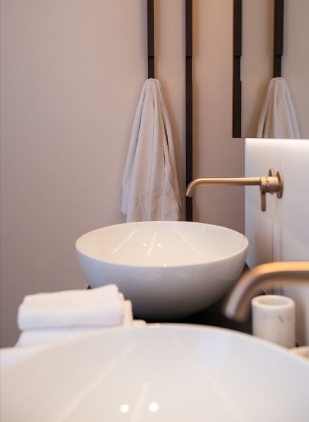 Luxuriöser Doppelwaschplatz im Appia Projekt Gargnano mit modernem Design-Zubehör und flauschigen weißen Handtüchern die das exklusive Wellness-Ambiente der Suite unterstreichen
