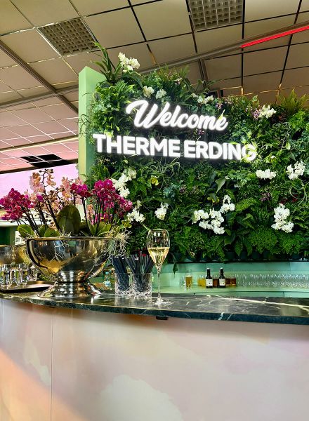 Grüne Mooswand mit Leuchtschriftzug Welcome Therme Erding