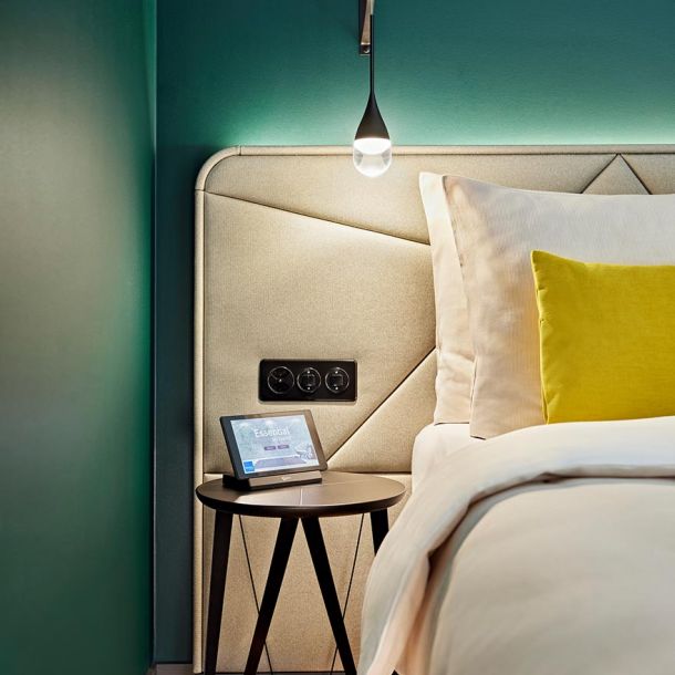 Hotelbett mit Beistelltisch und Leuchte