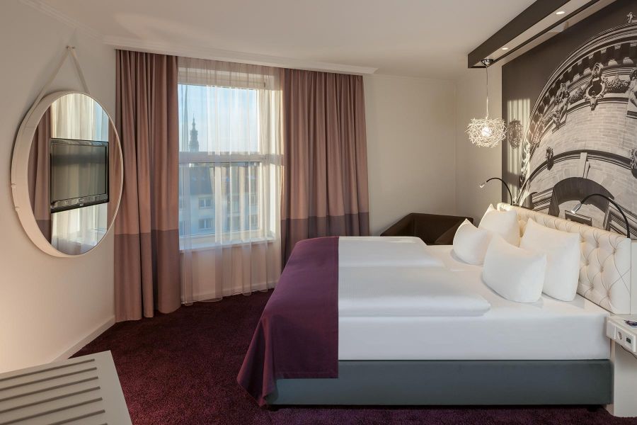 Hoteleinrichtung mit Doppelbett und rundem TV-Board