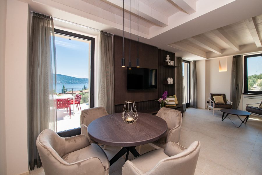 Exklusiver Essbereich mit stilvoller Tischdeko geometrischem Kerzenhalter und Panoramafenster zur Terrasse im Appia Projekt Gargnano Maison Selva Superior De Luxe Apartment