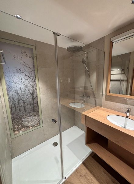hotel bathroom with a high-quality washstand and printed glass in the shower