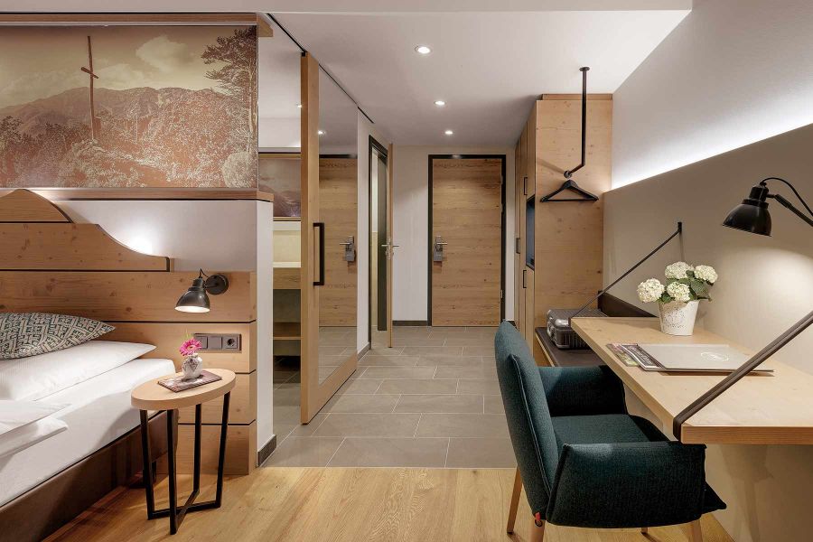 Zimmer mit Schreibtisch, Bergmotivbild und Holzelementen