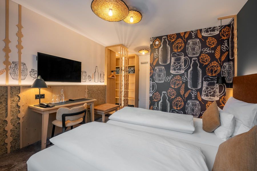 Doppelzimmer mit Wandverkleidung aus Heu und Holz