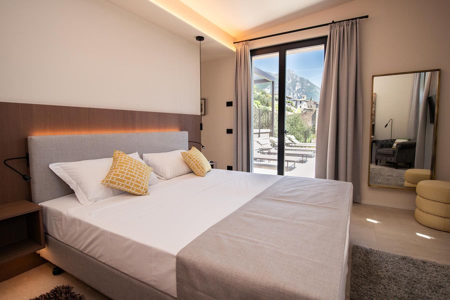 Schlafzimmer mit Ausblick auf Gargnano und Gardasee in warmen Farben und Interior