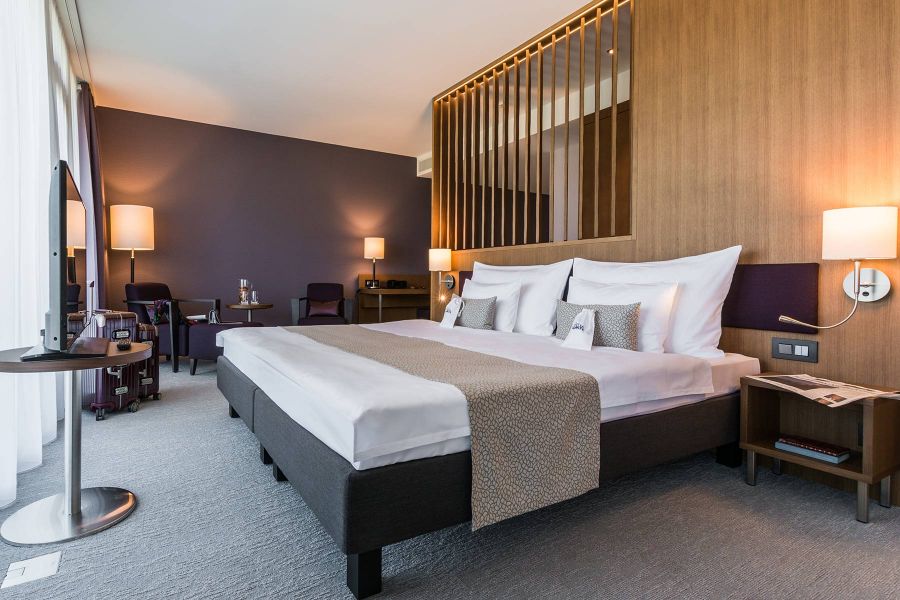 Suite des Deltaparks mit Doppelbett und Lamellentrennwand in warmen Brauntönen