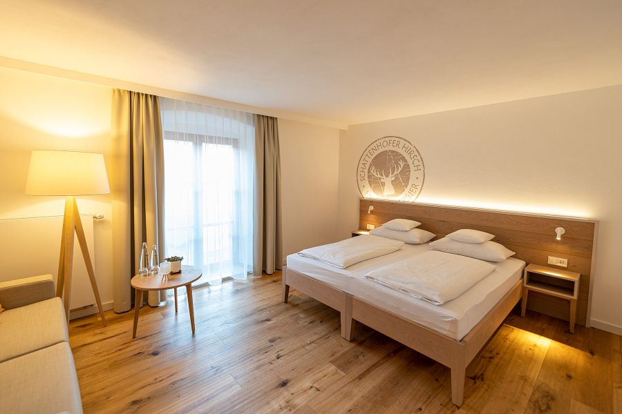 Hotelzimmer mit hotelspezifischem Wandmotiv und rustikaler Einrichtung