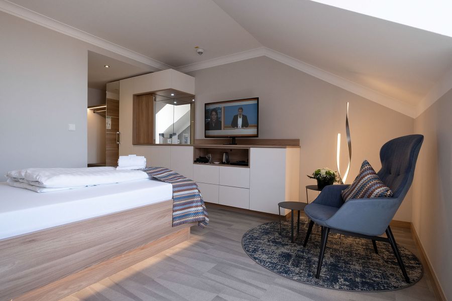 Klinikhotel-Zimmer mit Einbaubauschrank und Relax-Sessel
