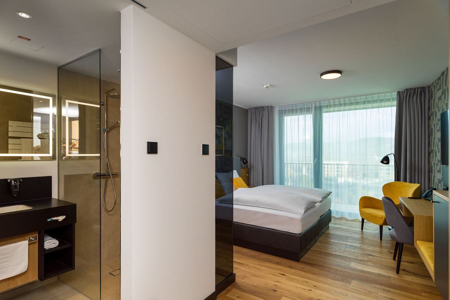 Modernes Hotelzimmer mit offenem Bad im Park Hotel Hagenberg