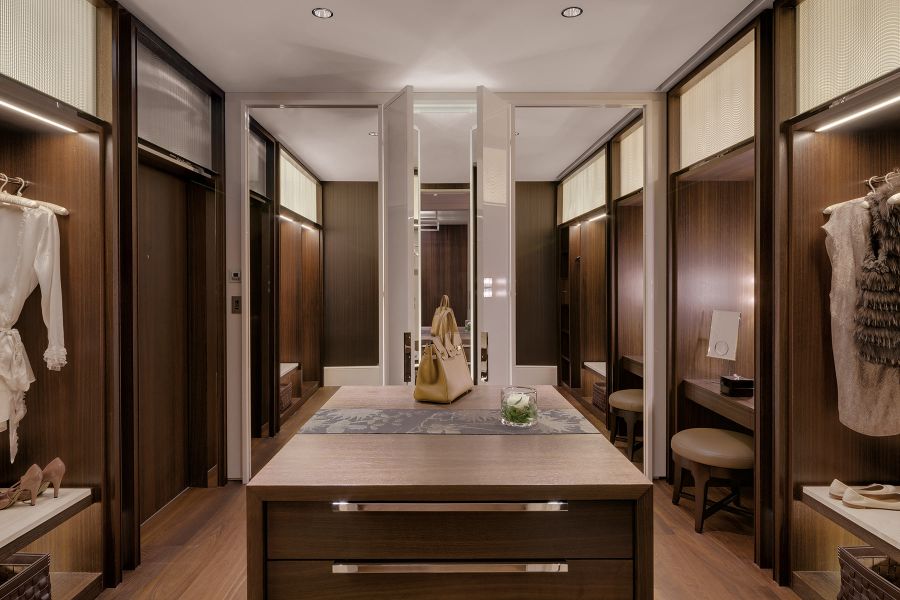 Weiträumige Ankleide mit hochwertigen Schreinermöbeln und indirekter Beleuchtung