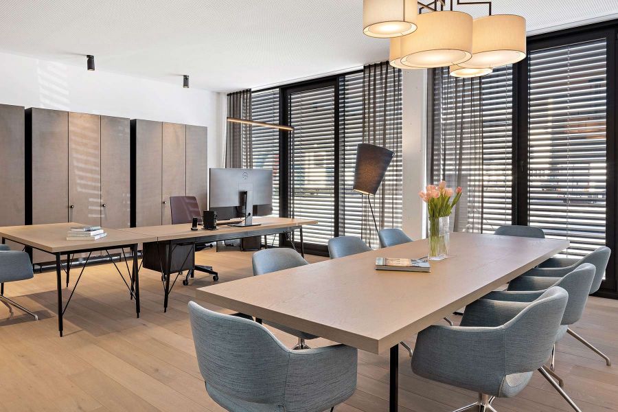 Großzügig gestaltetes Büro mit Bürotisch und Tisch für Besprechungen