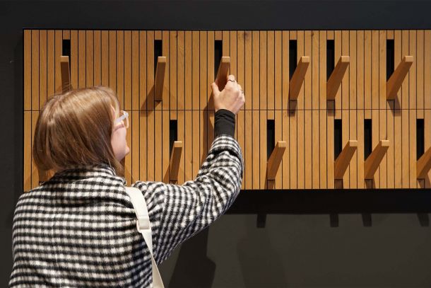 Garderobenbereich im Dorint Business Campus Garching mit wandmontierten Garderobenhaken aus Holz und lamellenartiger Rückwand in warmer Holzoptik aus der Appia Schreinerei