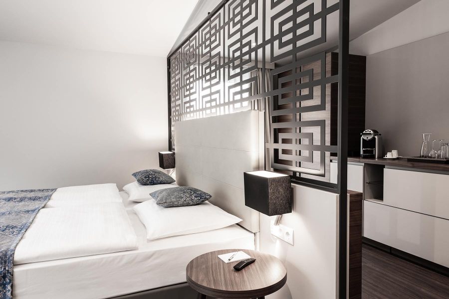 Bett mit Trennwand mit grafischem Muster in Grautönen