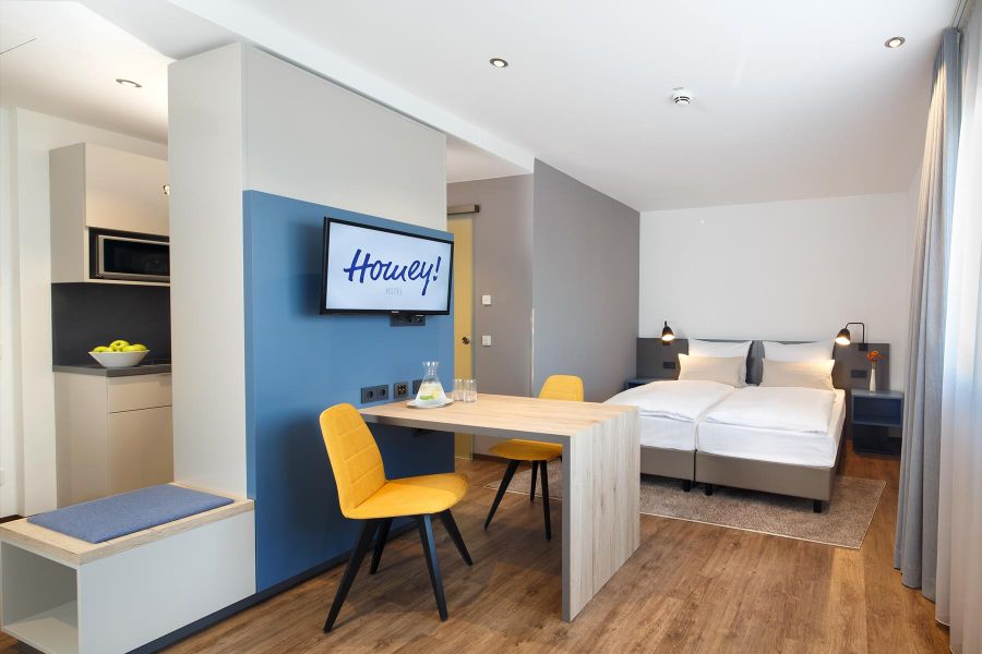 Hoteleinrichtung des Studios mit Küche, Doppelbett und Tisch