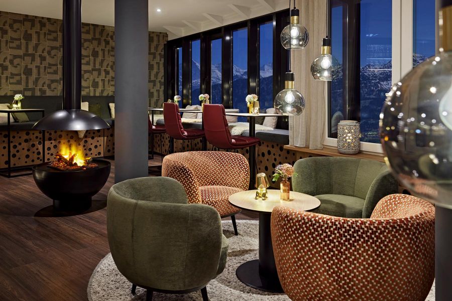 hotel furnishings in the lobby with colorful armchairs and fireplace