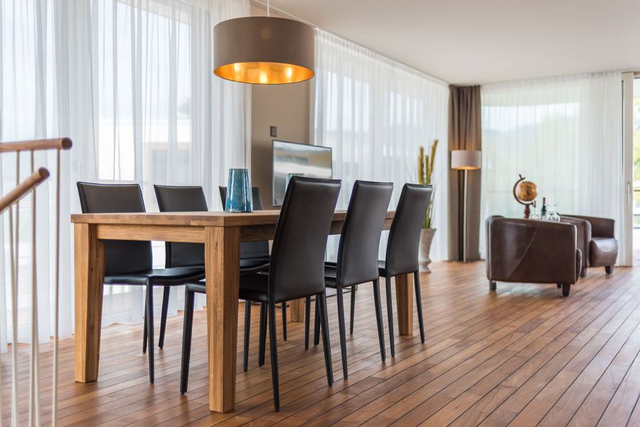 Essbereich Seevilla mit dunkelbraunen Ledersesseln und goldenen Akzenten