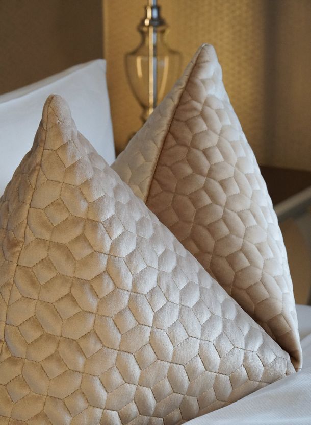 Hotelzimmer im Gasthof Schäfflerwirt Aschheim mit royal wirkenden Zierkissen in strukturierter Stoffoptik auf frisch bezogenem Bett