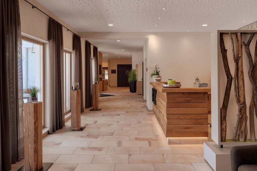 großzügiger Hotelflur in natürlichen Farben und mit Holzelementen 