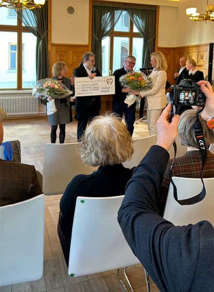 Bei Eröffnungsfeier im Parkhotel Biberach Jordanbad werden Blumen und ein Scheck überreicht.