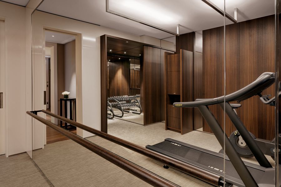 Laufband und Laufrad sowie verschiedene Hanteln im luxuriösen Fitnessstudio eines 5-Sterne-Hotels 