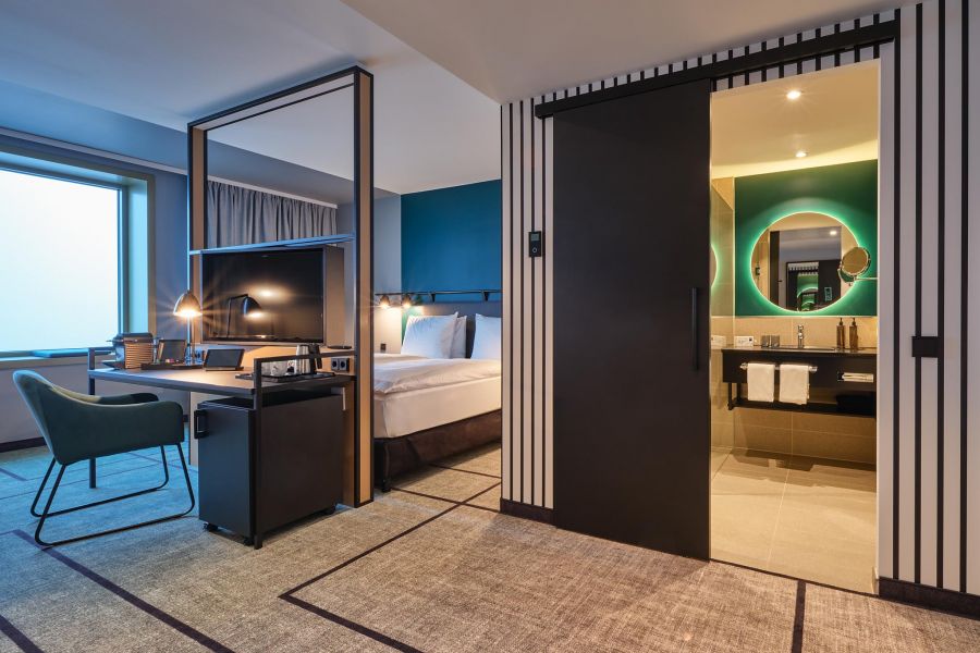 Zimmer mit Raumtrenner und Arbeitstisch und Bad