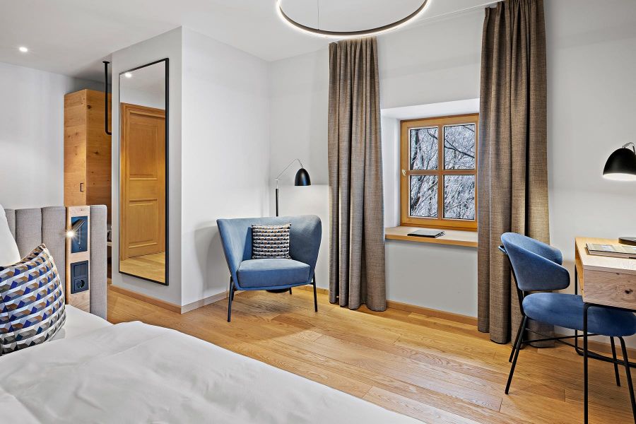 Großzügiges Zimmer mit Ankleide, Lounge, Schreibtisch und Bett in Kreuth 